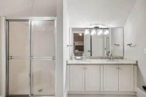 A bathroom with two sinks and a shower.