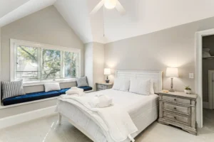 A bedroom with white walls and furniture.