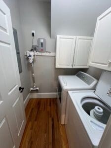 A white laundry room with a washer and dryer.