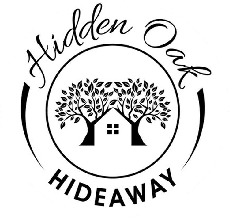A logo featuring the text "Hidden Oak Hideaway" with a house surrounded by two oak trees encircled within a border.