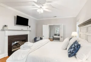 A bedroom with a fireplace and a large bed