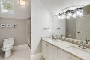 A bathroom with two sinks and a large mirror.