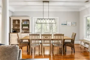 A dining room table and chairs in the middle of a living room.