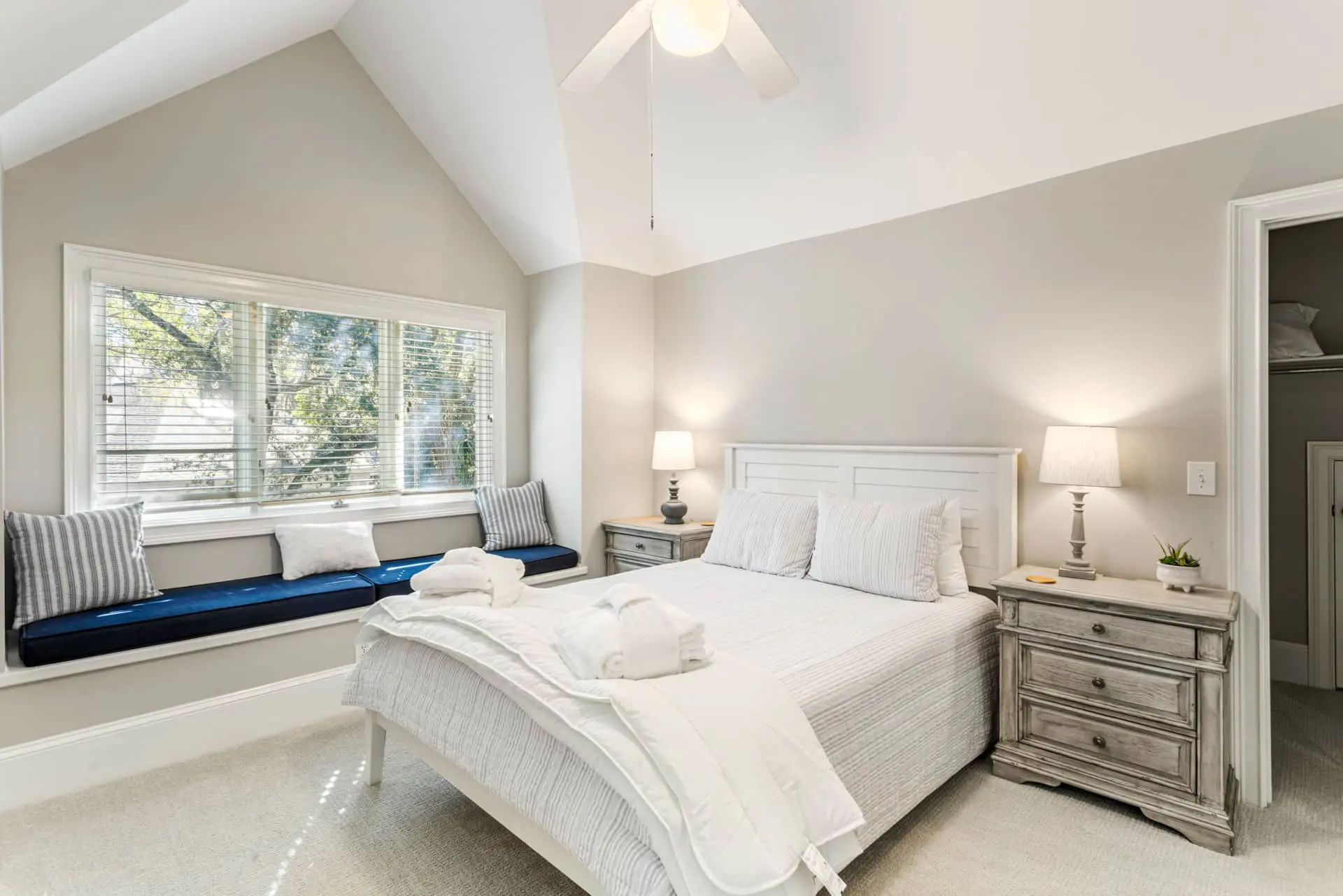 A bedroom with white walls and furniture.