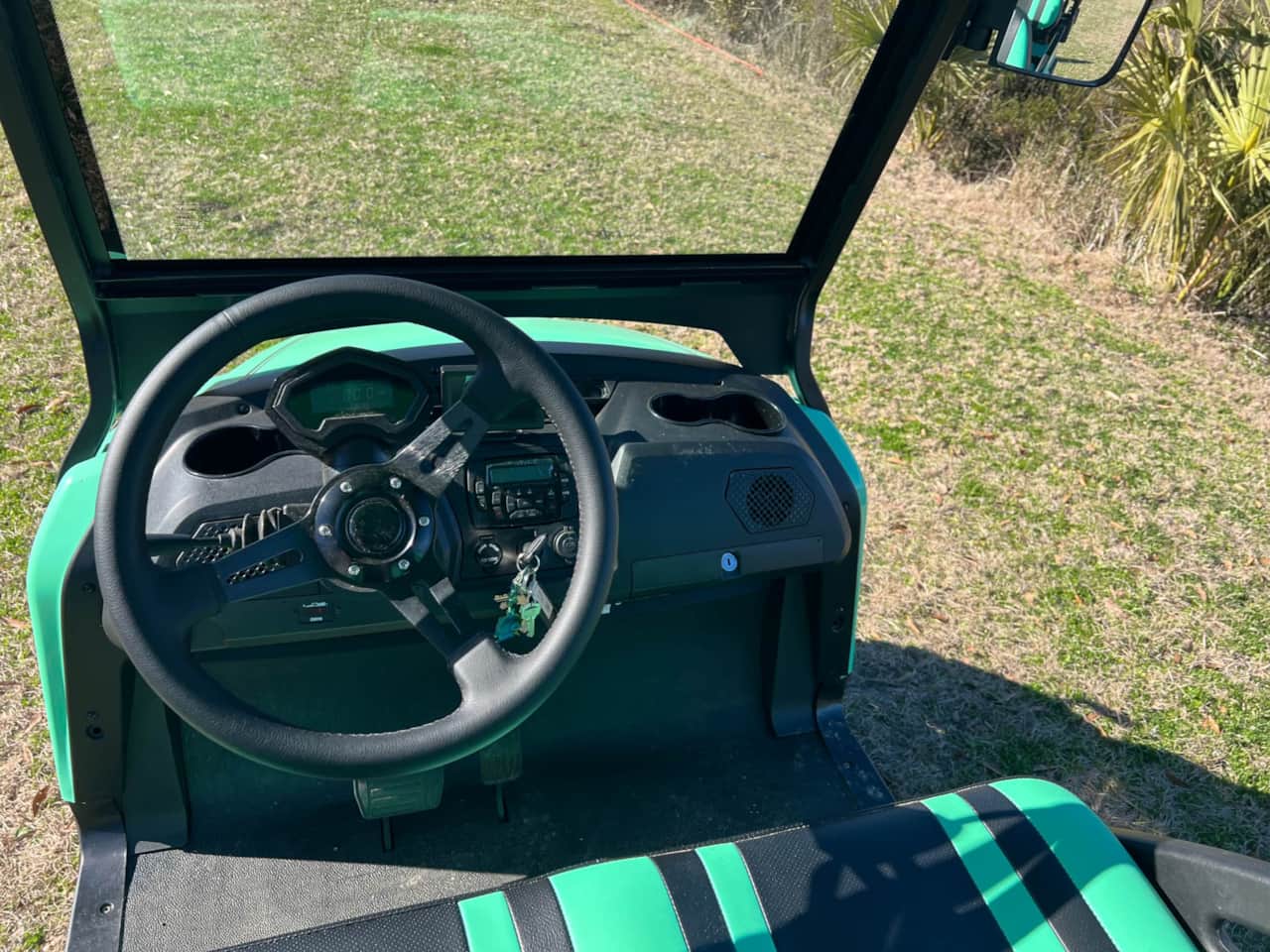 A close up of the steering wheel and dashboard on a golf cart.
