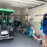 A golf cart in the garage with many items on it.
