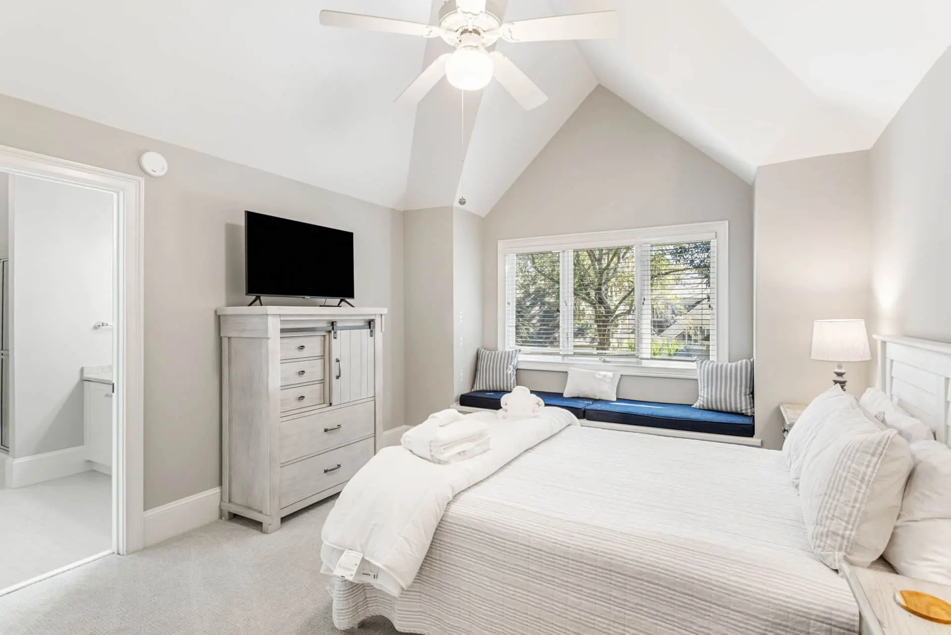 A bedroom with white walls and furniture.
