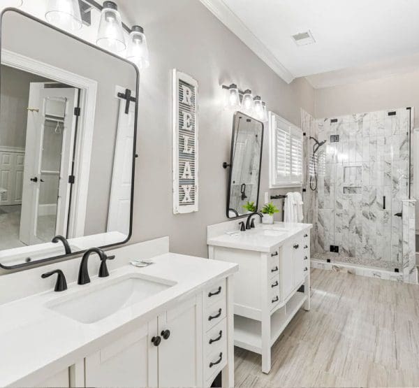 A bathroom with two sinks and a walk in shower.