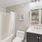 A bathroom with white walls and black cabinets.