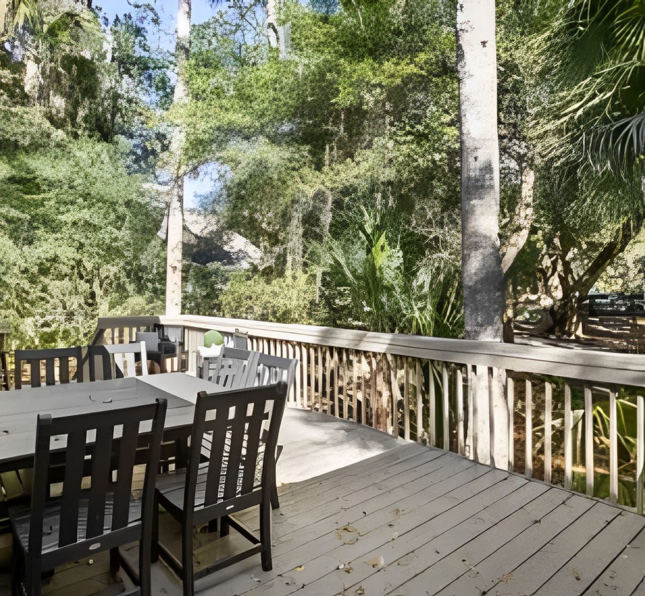 A wooden deck with chairs and tables on it.